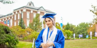 Husna Ahmadi smiles in blue cap and gown