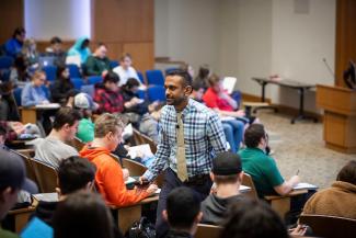 Professor engages with class in auditorium setting