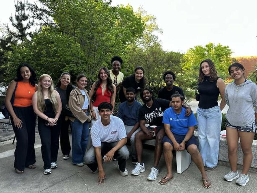Students pose in front of rock wall